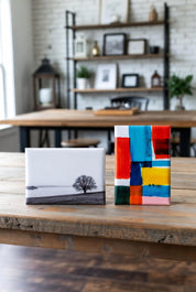 Two custom rectangle photo magnets on a wooden surface with a blurred indoor setting.