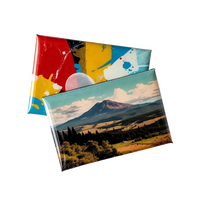 Two custom magnets with colorful abstract design and mountain landscape on a white background